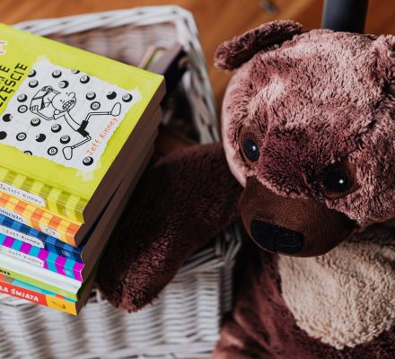 brown bear plush toy and stack of books