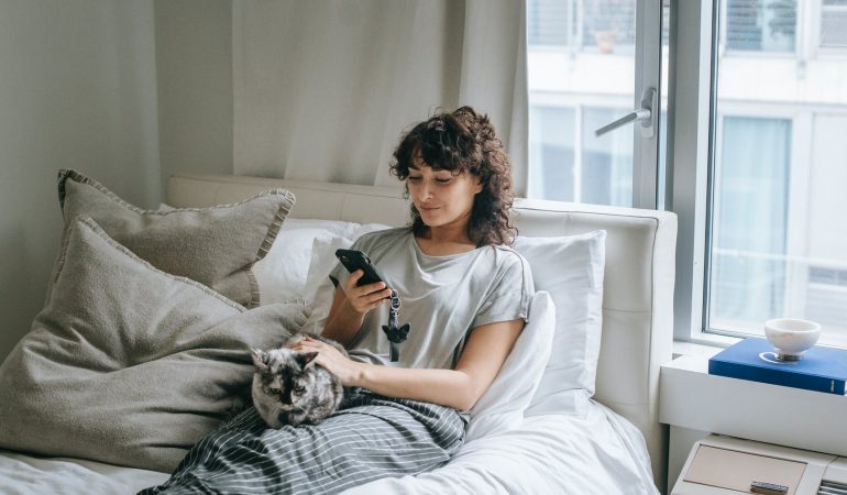 content woman browsing smartphone near cat
